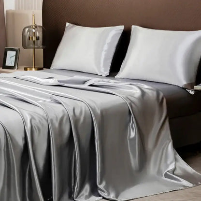 Silver satin flat sheet and matching white silk pillows in the decorbites opulent solid color satin bedding set