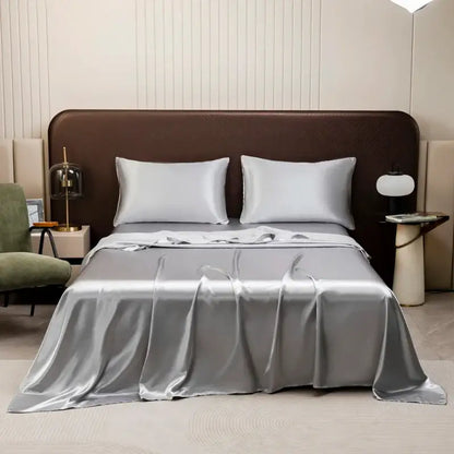 Silver satin bedding set from decorbites opulent collection featuring a flat sheet and matching pillowcases on a modern bed