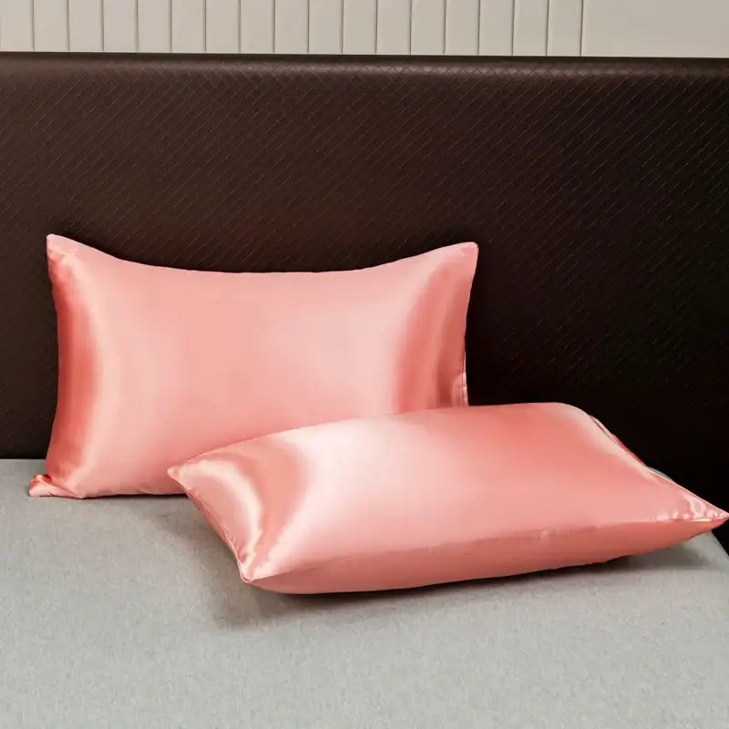 Two blush pink satin pillowcases with a smooth glossy finish from the decorbites opulent satin bedding set
