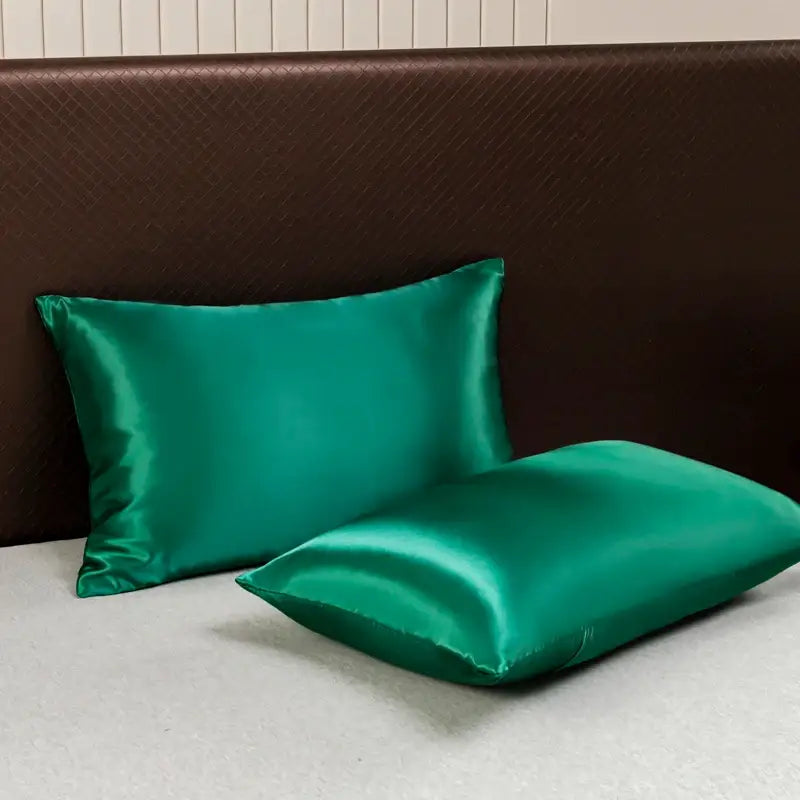 Two emerald green satin pillowcases with a smooth glossy finish from decorbites™ opulent satin bedding set