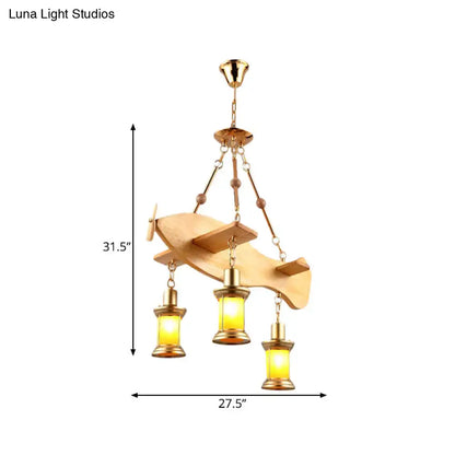 A golden airplane-shaped pendant light with wooden wings and brass lanterns featuring fish guitar design accents