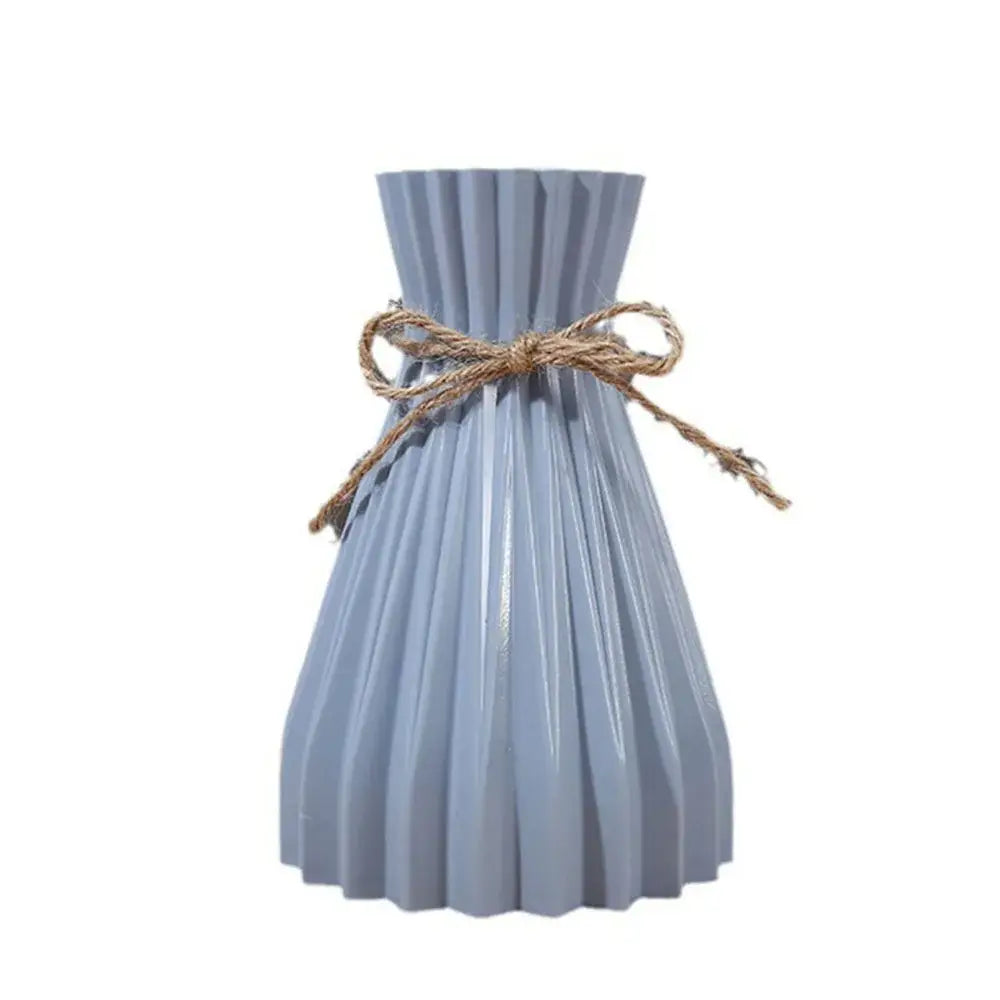 Light blue pleated DecorBites™ origami vase made of plastic adorned with a rustic twine bow for flowers