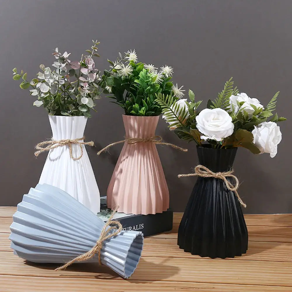 Set of three modern origami style plastic flower vases in white, blush pink, and black with rustic twine ties
