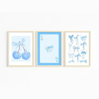 Set of three framed watercolor wall art prints in soft pastel blues featuring blue cherries ace card and pink bows art set