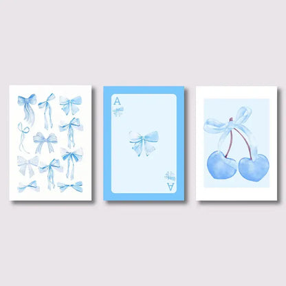 Set of three DecorBites™ wall art prints featuring blue bows, cherries, and an ace card in watercolor-style design