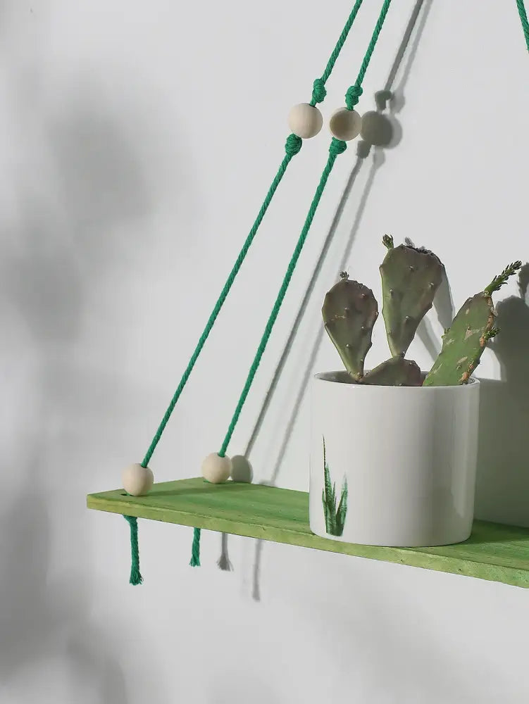 Decorbites™ pink green wooden wall shelf with green macrame, wooden beads, and white pot with prickly pear cactus