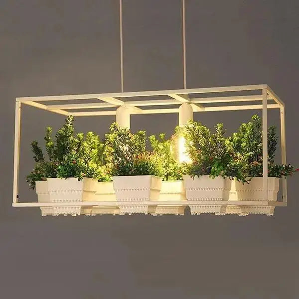 White rectangular DecorBites™ planter light chandelier with integrated planters holding lush green foliage