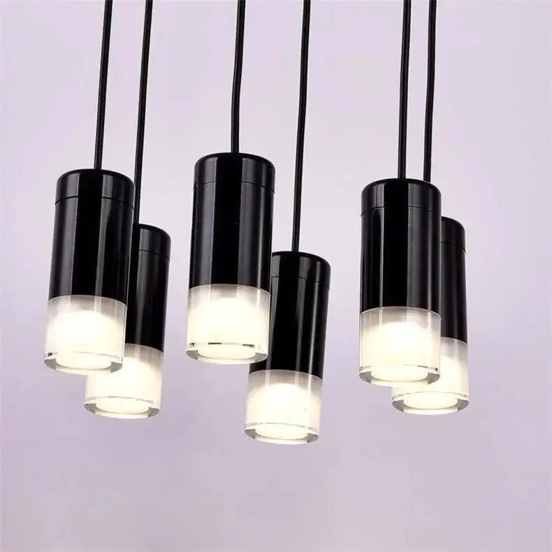 Black cylindrical decorbites™ plug-in hanging lights with frosted glass bases emitting soft white glow