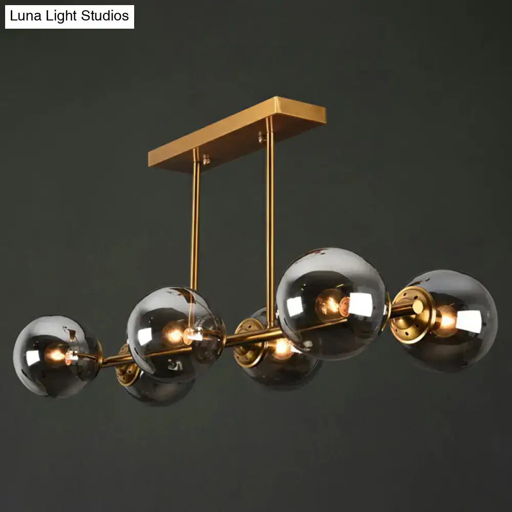 Modern brass-finished DecorBites™ island light with five smoked globe glass shades ceiling fixture