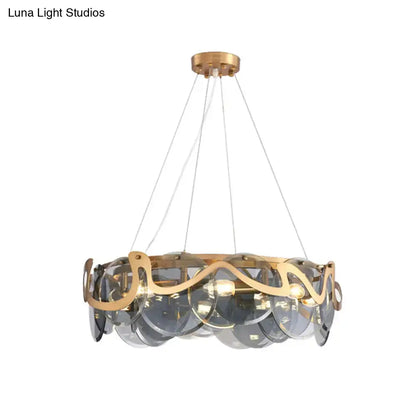 Gold-toned decorbites postmodern circle pendant light featuring translucent gray glass discs and ornate metal accents