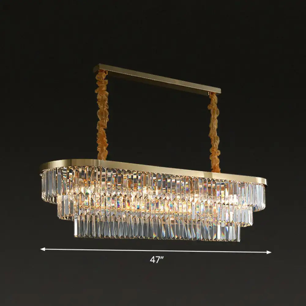 Gold-toned postmodern oblong island light with clear crystal rod prisms and twisted metal chains in brass finish