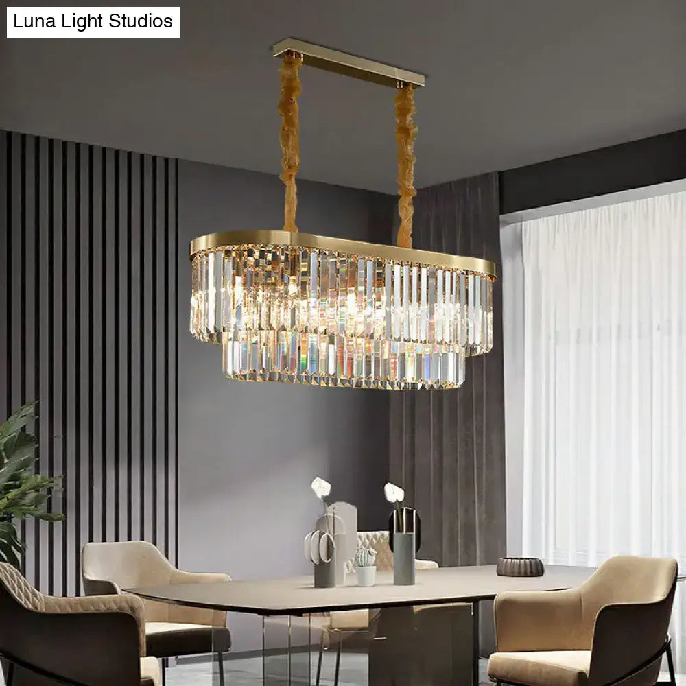 Gold-toned postmodern oblong island light with cascading clear crystal rods in a brass finish for dining room use