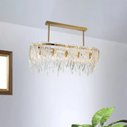 Elegant gold-toned DecorBites™ postmodern crystal island pendant light with cascading prisms for dining room use