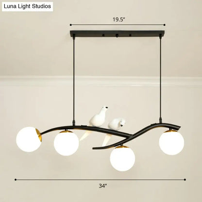 Black metal decorbites island lamp tree with three white glass globes and ceramic bird figurines on lamp tree branch design