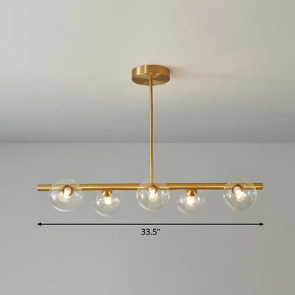 DecorBites postmodern brass pendant light with four clear glass globes and linear island lamp design for dining room