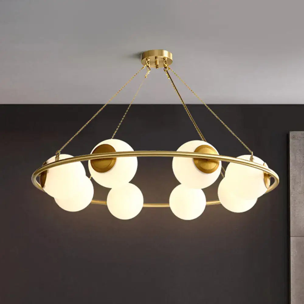 Decorbites postmodern circular chandelier light with brass finish and frosted glass globe shades suspended by chains