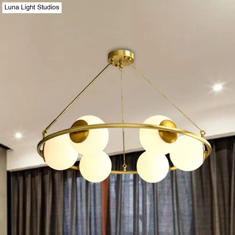 Decorbites postmodern circular chandelier light with brass finish and five frosted glass globe shades