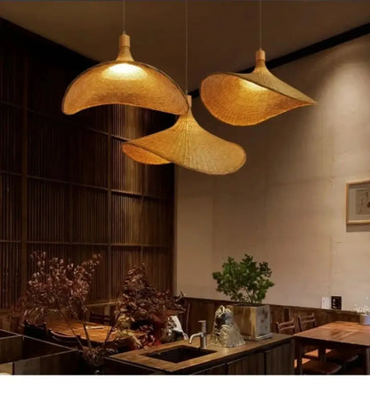 Three golden woven bamboo DecorBites™ rattan hanging pendant lights with dimmable shades hang from the ceiling