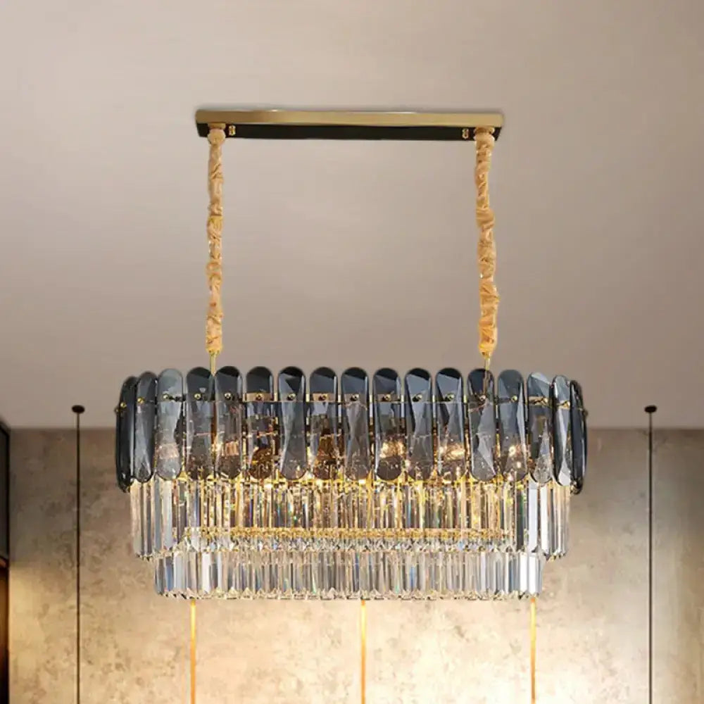 A modern decorbites smoke gray rectangular dining room pendant with three-tier amber and clear crystal blocks suspended by twisted gold cords