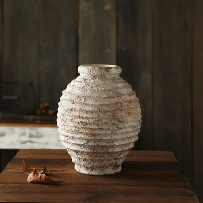 DecorBites™ retro handmade clay vase in off-white with horizontal ridges and weathered texture on wooden surface