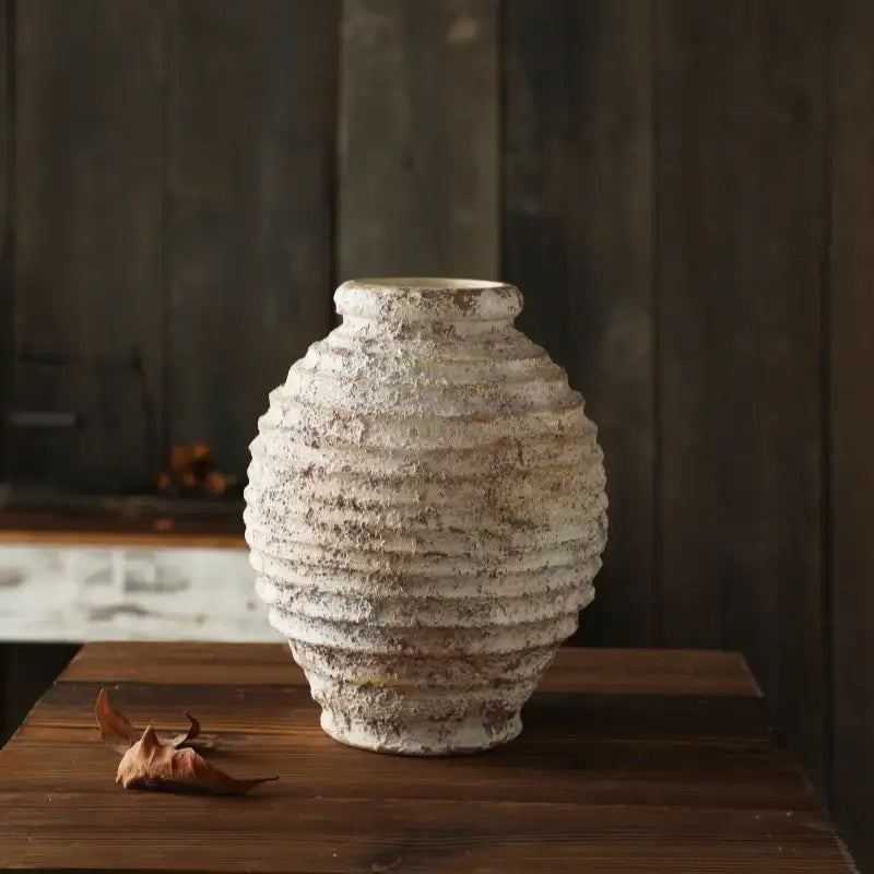 DecorBites™ retro handmade clay vase in off-white with horizontal ridges and weathered texture on wooden surface