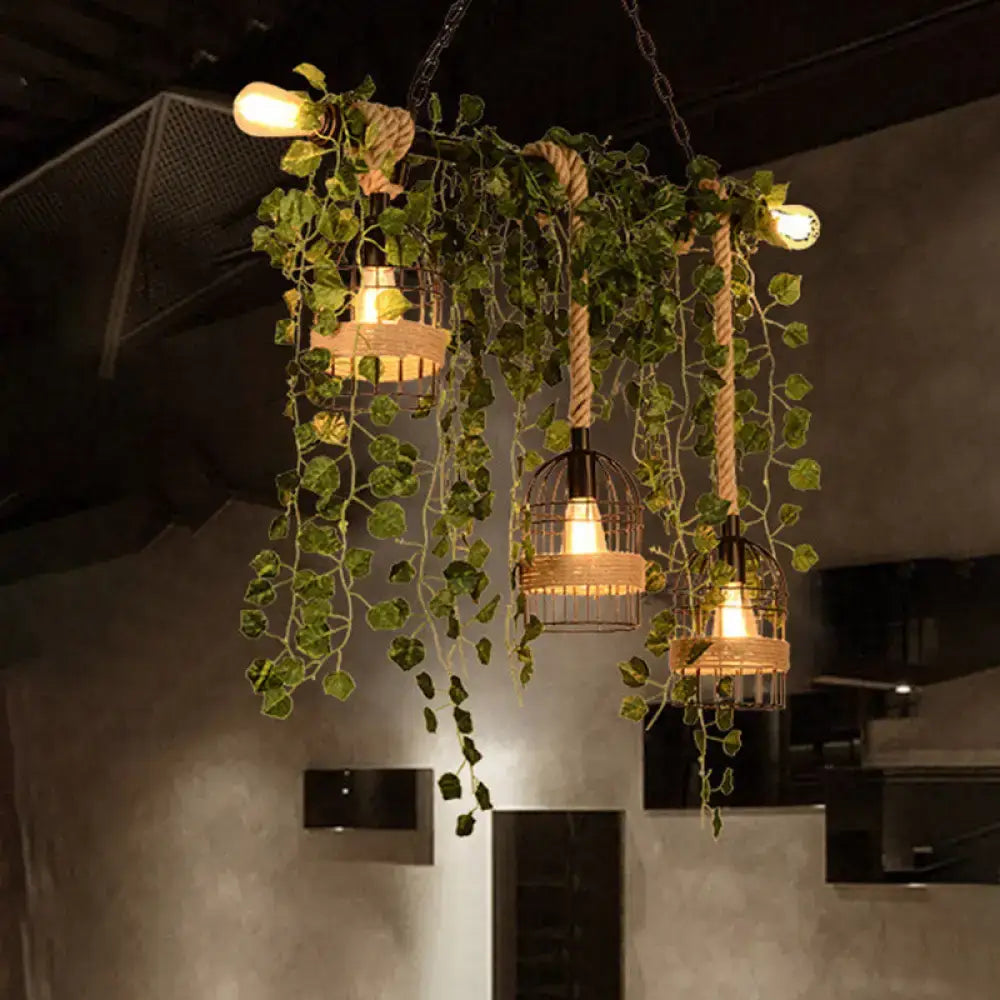 A rustic DecorBites retro metal island light with three wrought iron birdcage lamps and green ivy for restaurants