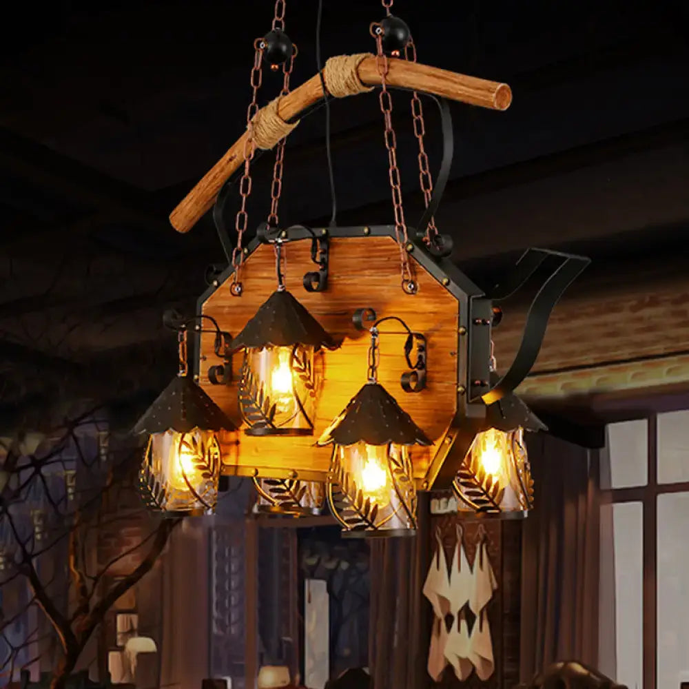 Rustic wooden and black metal teapot-shaped chandelier with four glowing glass lanterns and white fabric clear glass shade
