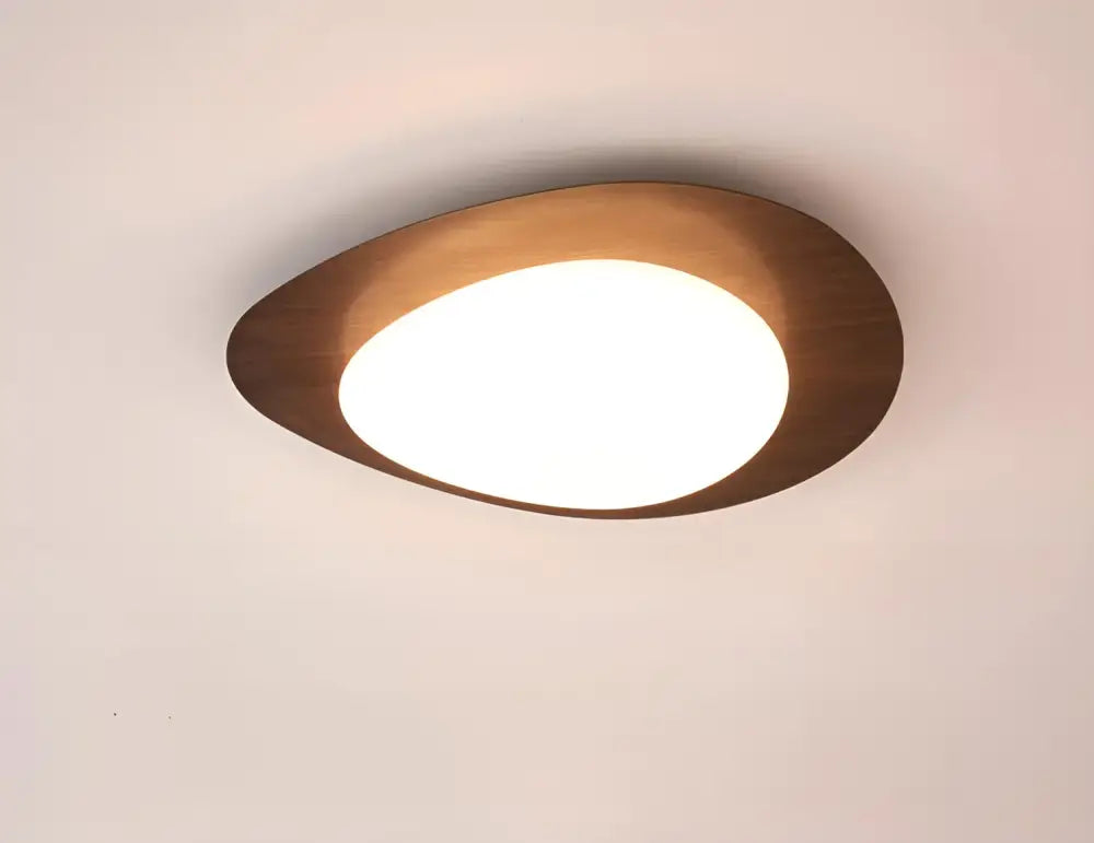 Modern teardrop-shaped decorbites™ ceiling light in walnut color with warm brass finish and white illuminated panel for living room