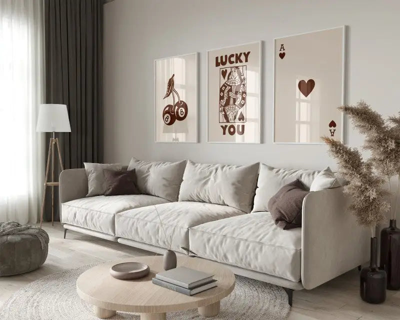 Beige upholstered sectional sofa with dark brown pillows in a modern design paired with retro wall art posters set