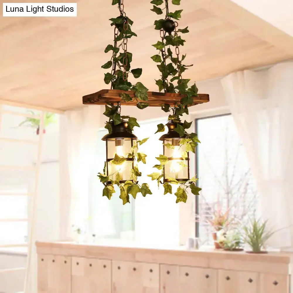 Rustic wooden beam island ceiling light with two lantern-style fixtures, dark metal frames, glass panels, and pink green plant flower decor
