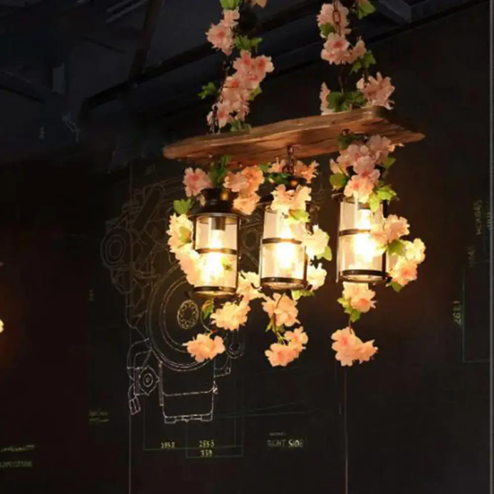 A rustic wooden shelf with three decorbites™ retro wooden lanterns island ceiling light featuring pink green plant flower decor