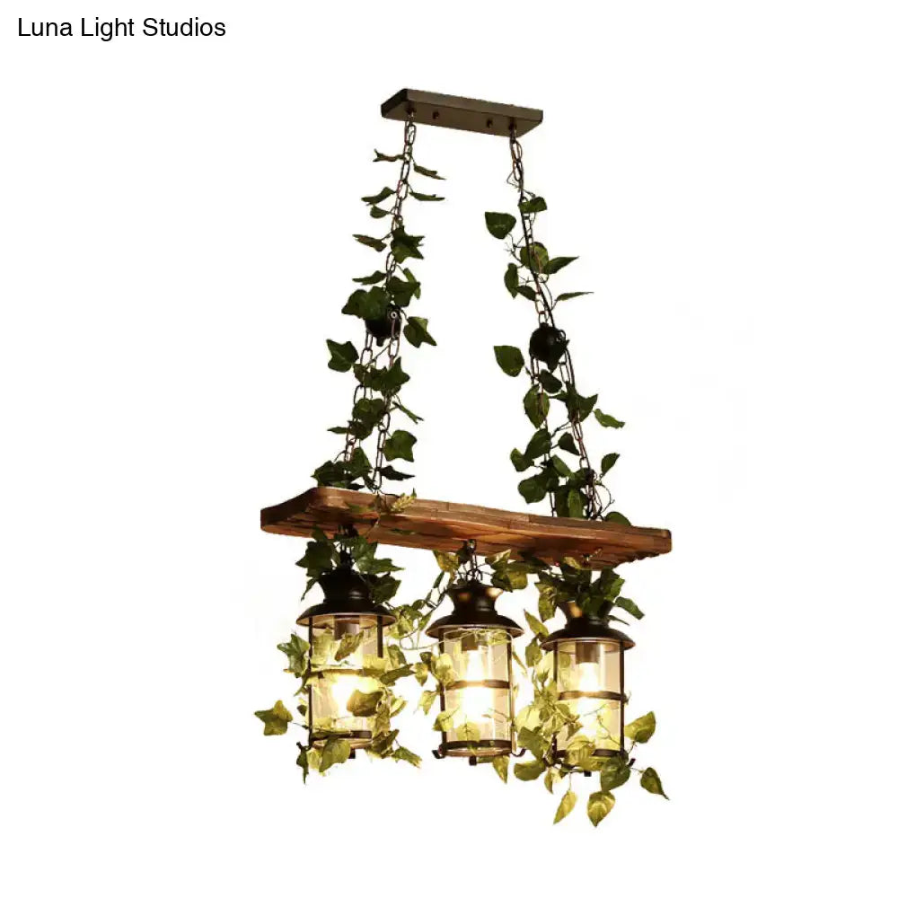 Rustic wooden beam island ceiling light with three lantern-style lights pink green and hanging plant flower decor