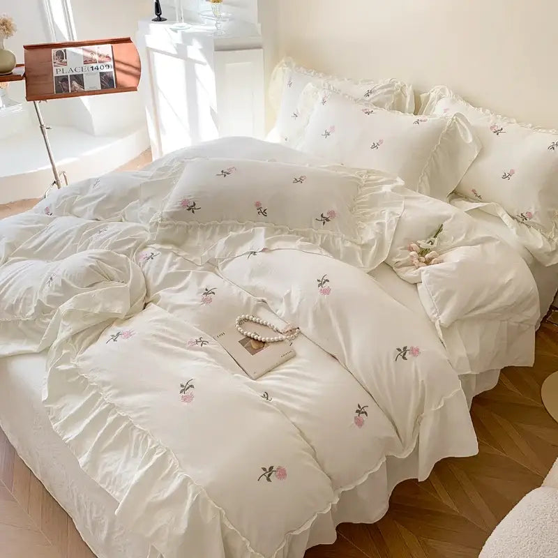 Cream-colored DecorBites™ rose embroidered duvet cover set with delicate pink green floral embroidery and ruffled edges