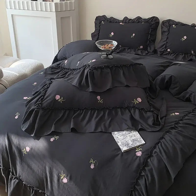 Black satin DecorBites™ rose embroidered duvet set with delicate pink floral embroidery and layered ruffled edges