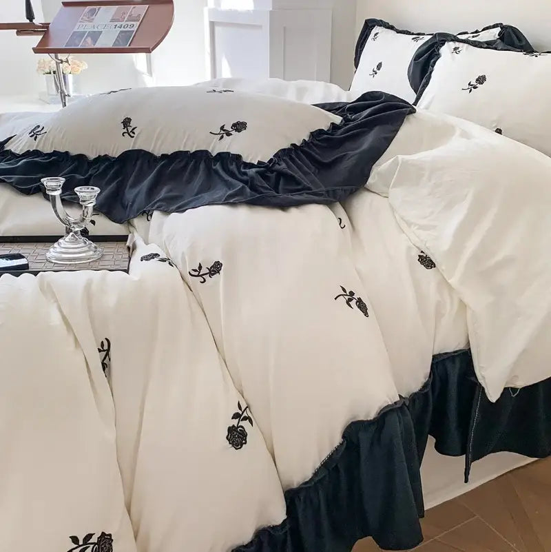 Cream-colored decorbites™ rose embroidered duvet set with black floral embroidery and navy blue ruffled trim princess style