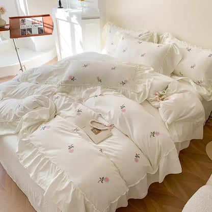 Cream-colored decorbites™ rose embroidered duvet set with delicate pink green floral embroidery and ruffled edges