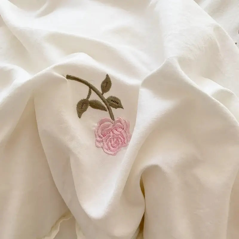 DecorBites™ rose embroidered duvet set with delicate pink rose and green stem stitched on soft white fabric