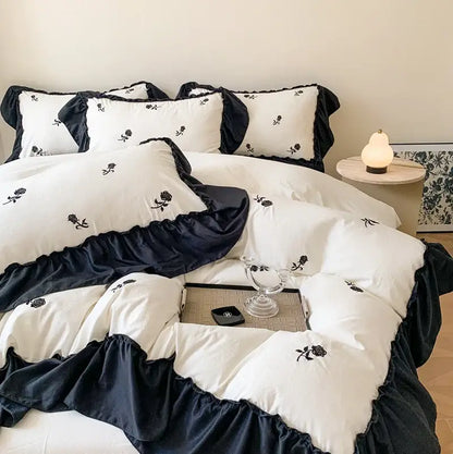 DecorBites rose embroidered duvet set featuring white and navy blue ruffled bedding with black rose embroidery