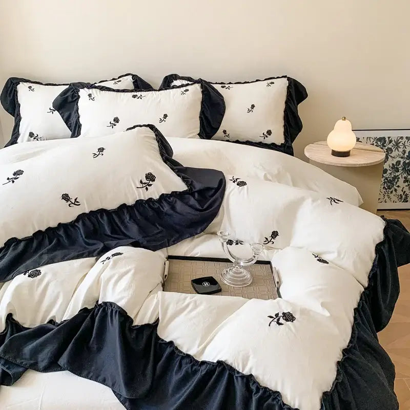 DecorBites rose embroidered duvet set featuring white and navy blue ruffled bedding with black rose embroidery