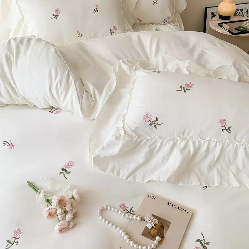 White pillow with delicate pink rose embroidered design and ruffled edges from decorbites rose embroidered duvet set princess style