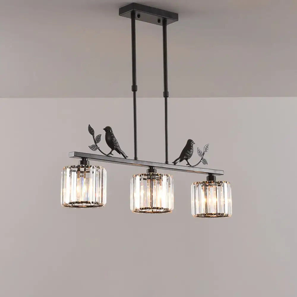 Black metal pendant light with three cylindrical crystal island shades and decorative bird motifs for dining room lighting