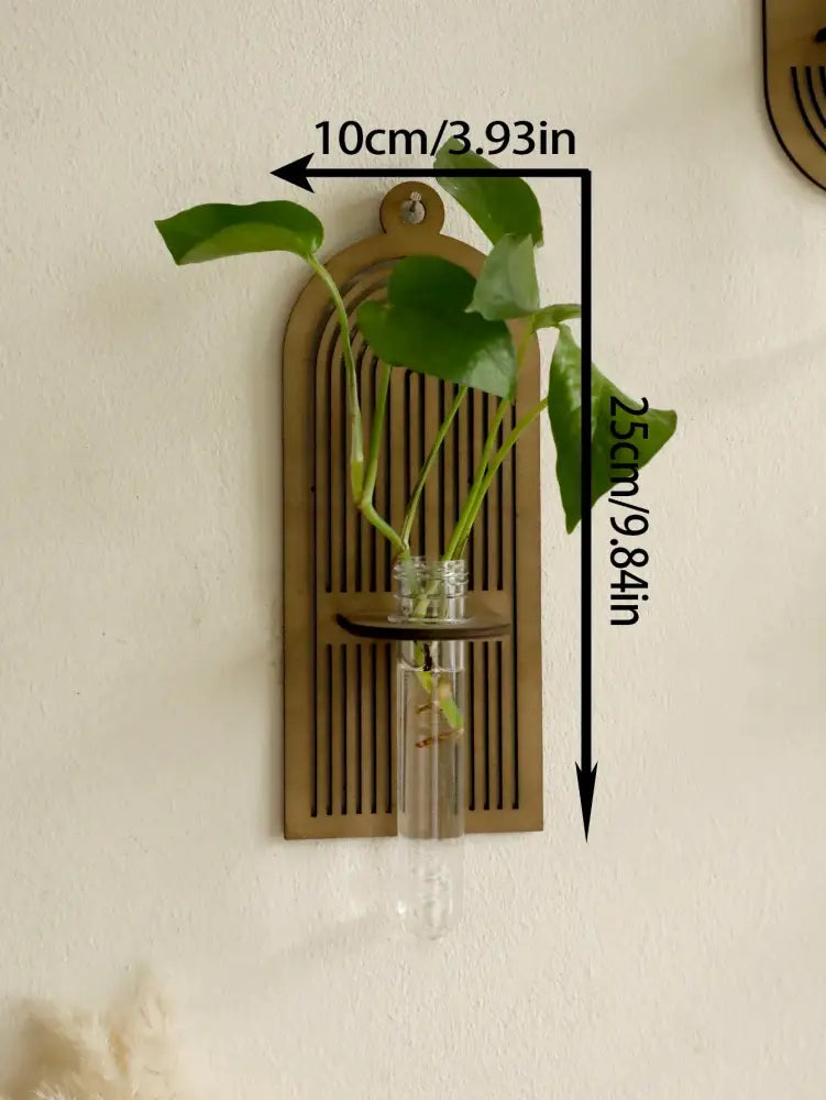 Brass arched wall vase with vertical slats holding a clear glass vase with greenery in a rustic wood wall design