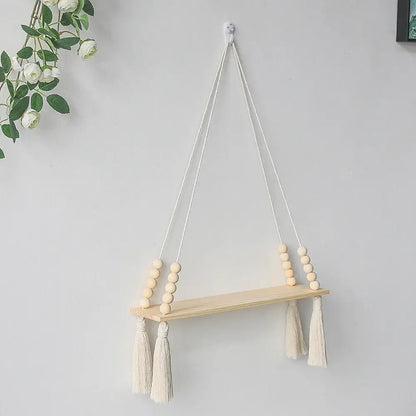 DecorBites™ rustic wooden wall shelf with natural wood finish hanging by white macrame cords with beads and tassels