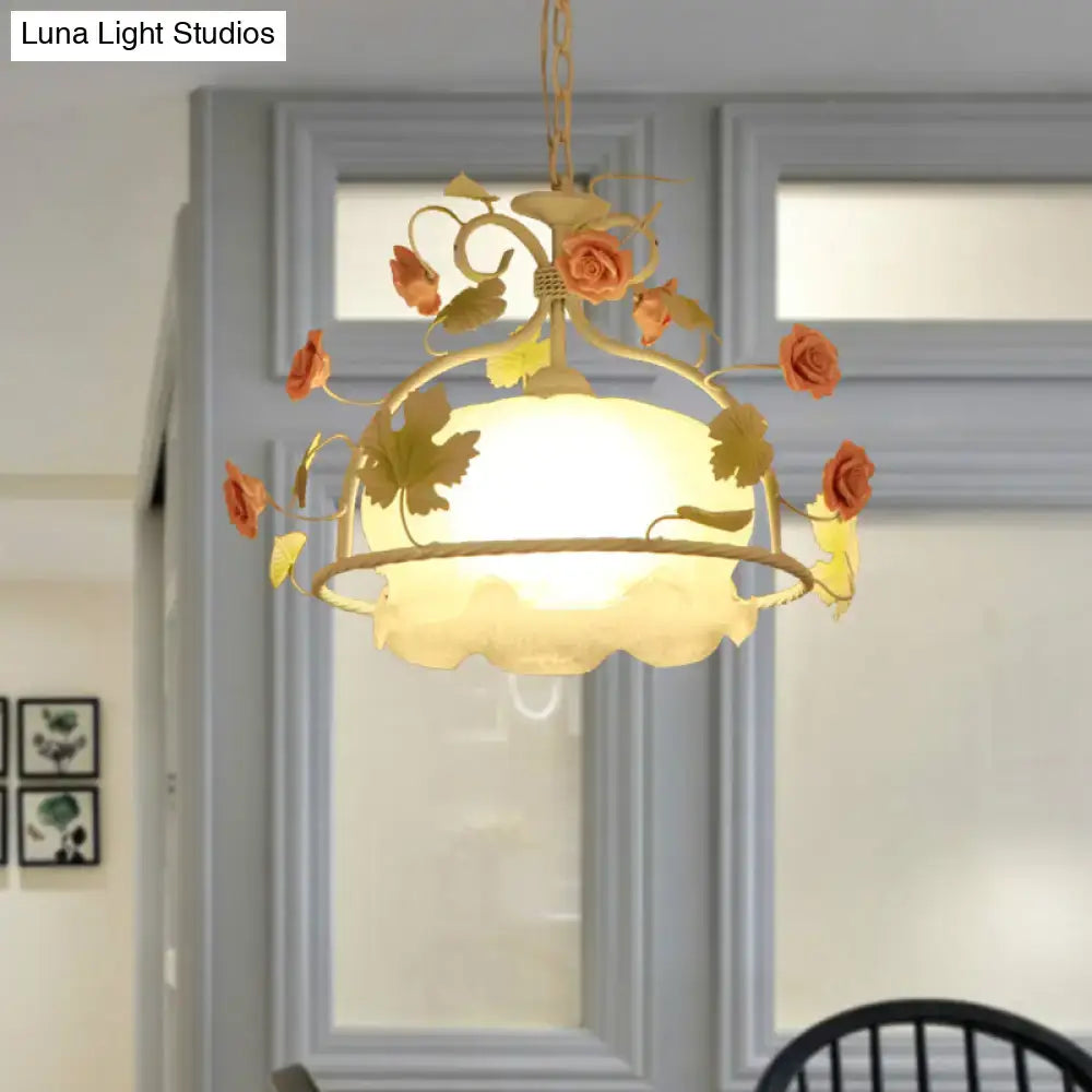 Delicate gold-toned scallop chandelier light fixture with orange roses and frosted opal glass shade for living room