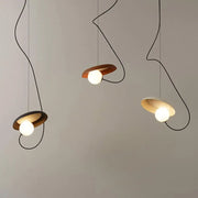 Decorbites™ scandinavian pendant light with three circular wooden shades, curved black cords, and glowing white bulbs
