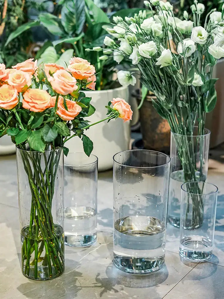 Tall clear acrylic cylinder vase by decorbites holding peach roses with green stems featuring shatterproof clear acrylic design