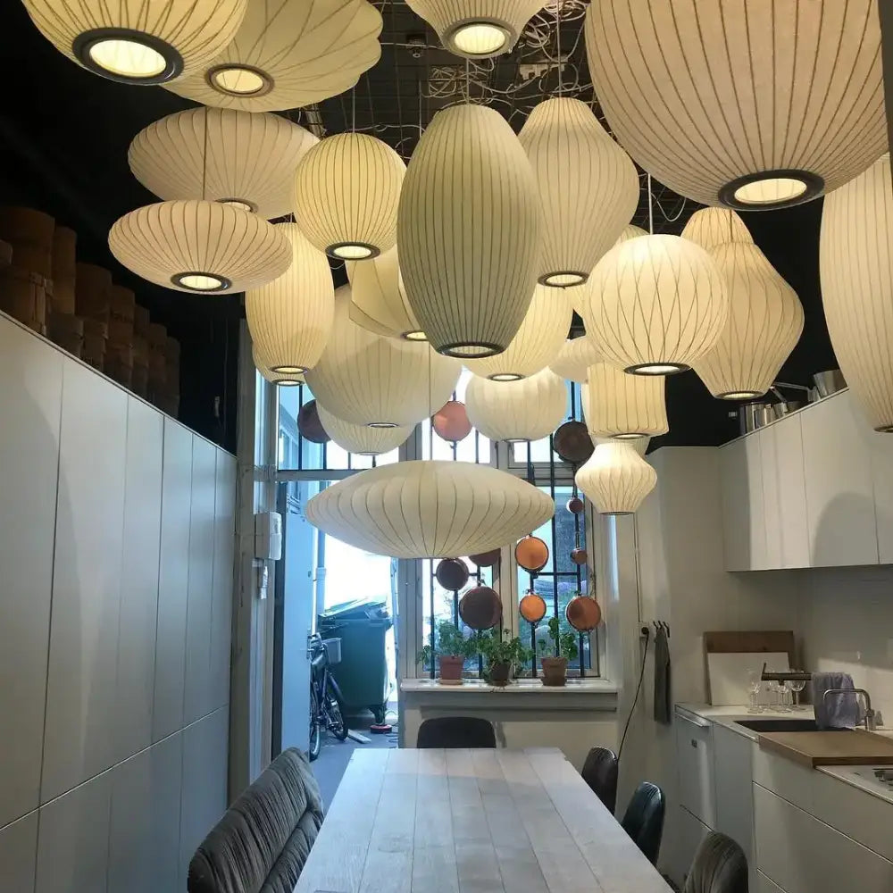 Cream-colored silk led pendant lamp with ribbed design and warm glowing lights for modern designer lighting