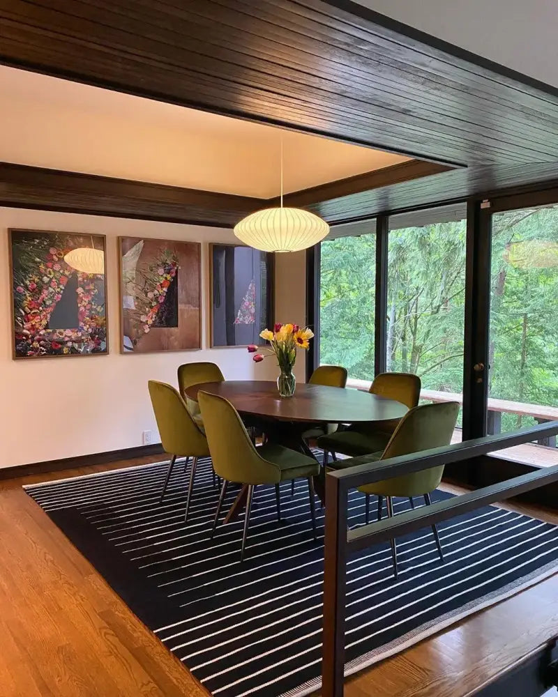 Olive green upholstered dining chairs with slender metal legs around dark wood table under decorbites silk led pendant lamp