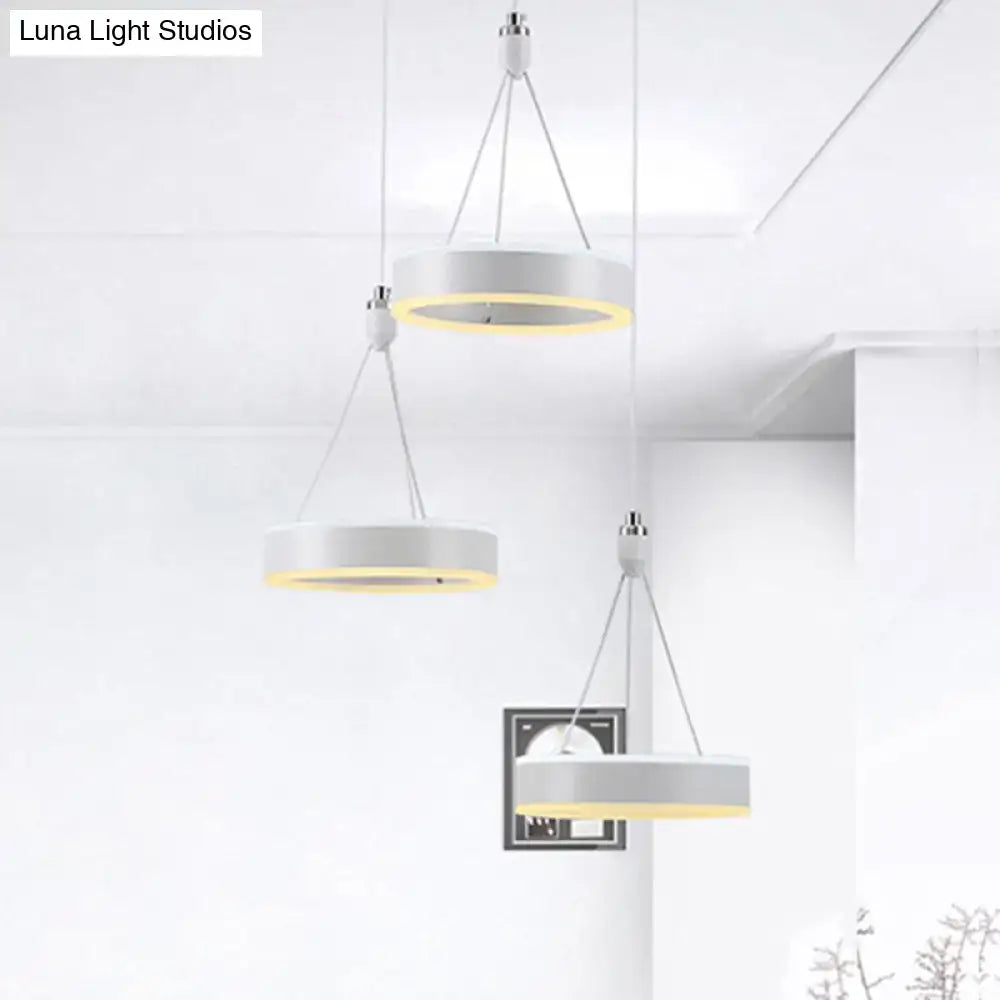 Modern white and silver cluster ceiling light with warm yellow glow and LED rings for dining room illumination