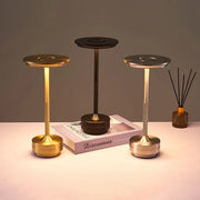 Three modern metallic desk lamps in gold black and silver feature simple charging led and dimming for versatile use
